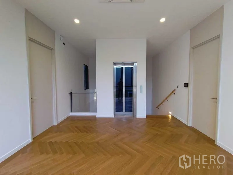 Detached House for rent in Wang Thonglang, Bangkok - Second-floor landing with elevator and warm wood floors.