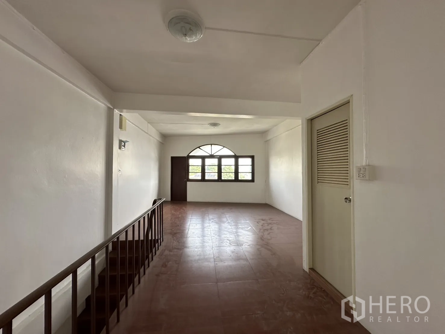 Shophouse for rent in Phra Khanong, Bangkok - Corridor leading to a room with an arched window.