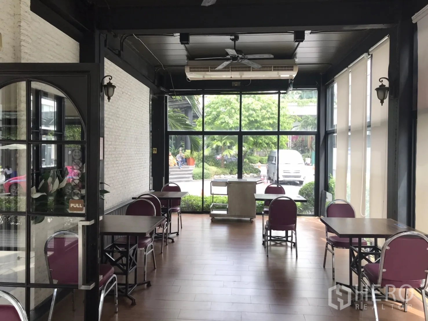 Retail Space for rent in Khlong Toei, Bangkok - Bright dining area with floor-to-ceiling windows, tables, chairs and wood flooring.