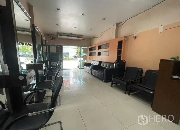 Shophouse for rent in Phra Khanong, Bangkok - Ground-floor retail area with sofas and glass entrance facing the street.