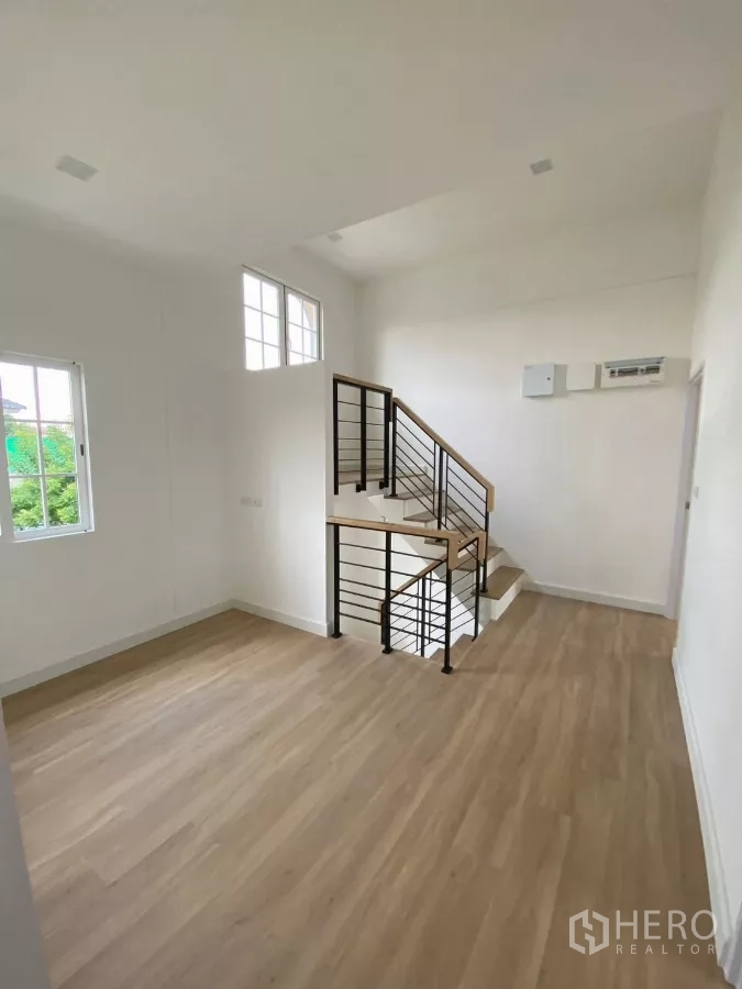 Detached House for rent in Bang Phli, Samut Prakan - Upper landing with wood flooring and modern staircase with black railings.
