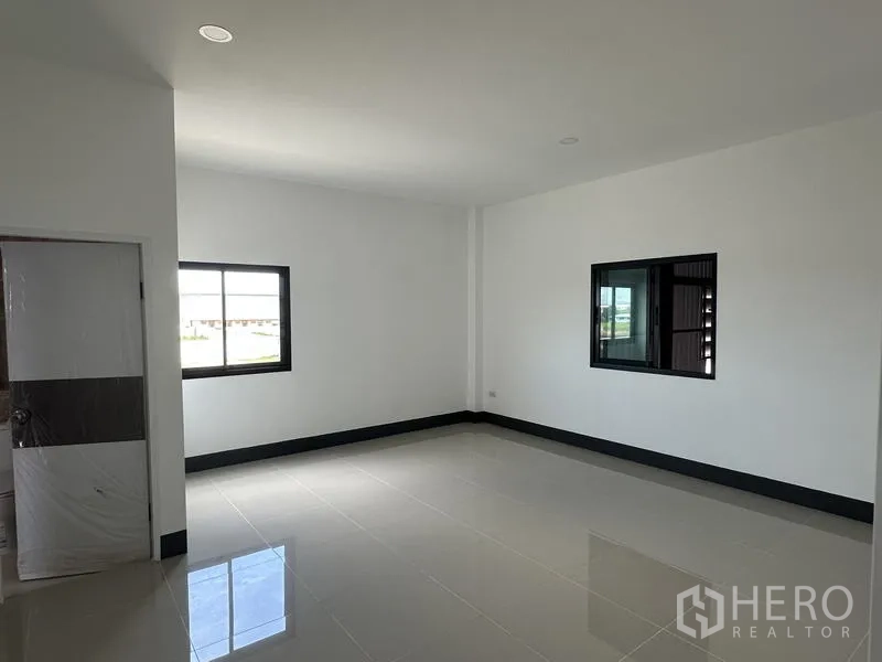Factory for rent or sale in Sai Noi, Nonthaburi - Upstairs office room with windows and doorway to a private restroom.