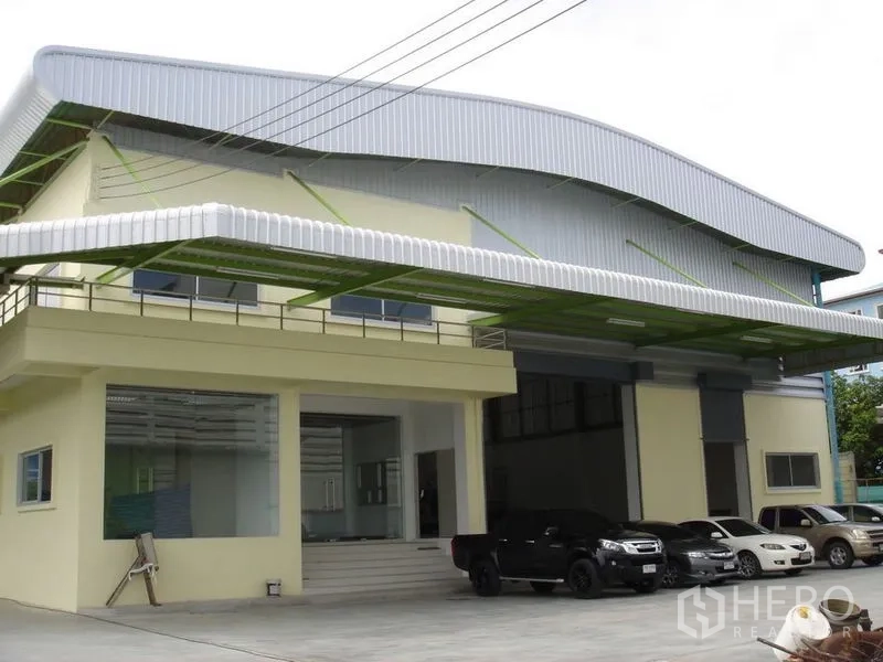 คลังสินค้า ให้เช่าในLat Krabang, Bangkok - ด้านหน้าโกดังพร้อมประตูม้วนคู่ หลังคากันสาด และลานจอดรถในพื้นที่