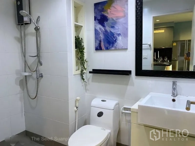 Condominium for rent or sale in Sathon, Bangkok - White-tiled bathroom with shower, vanity and large framed mirror.
