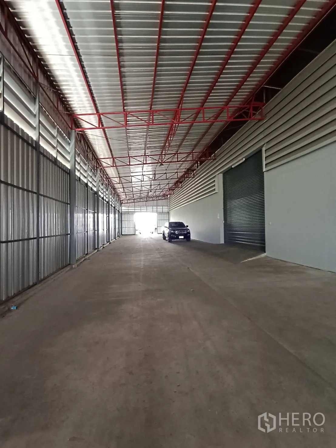 Warehouse for rent in Lat Krabang, Bangkok - Covered truck-access lane with metal cladding and loading ramps in front of shuttered bays.