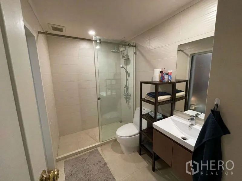 公寓 出售在Watthana, Bangkok - 现代浴室，玻璃淋浴间、盥洗台与坐便器。