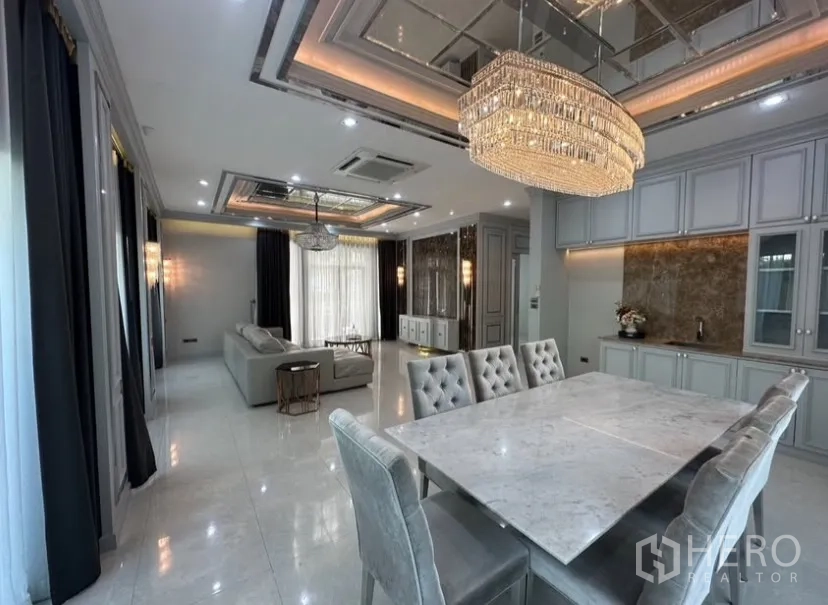 Detached House for rent or sale in Prawet, Bangkok - Luxurious living room detail with crystal pendant, black marble accent wall, and a round coffee table.