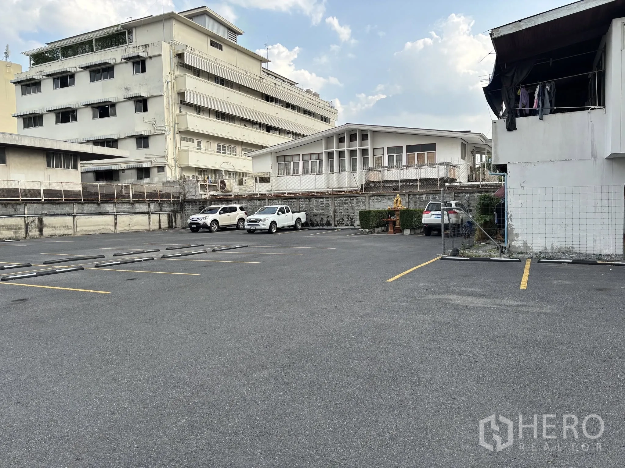 ที่ดิน for rent in Sathon, Bangkok - ลานปูยางมะตอย เส้นจอดชัดเจน มีกำแพงรอบพื้นที่และอาคารติดกัน