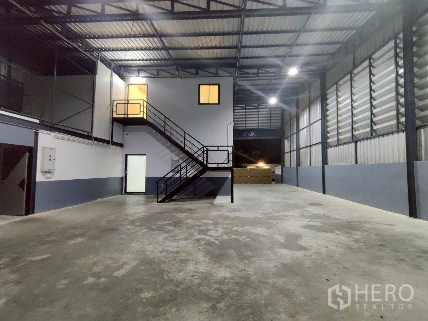 Warehouse for rent in Lam Luk Ka, Pathum Thani - Open warehouse bay with steel structure, lighting, and enclosed office rooms.