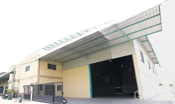 คลังสินค้า ให้เช่าในPathum Thani - ด้านหน้าโกดัง ประตูม้วนกว้าง หลังคาคลุมลานโหลด และประตูรั้วความปลอดภัย