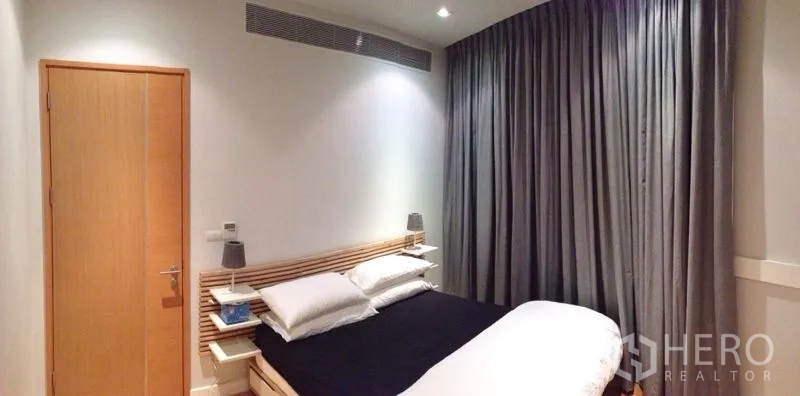 คอนโด ให้เช่าในRatchathewi, Bangkok - ห้องนอนอบอุ่น เตียงคู่ โคมไฟหัวเตียง และม่านทึบแสงแบบยาวจรดพื้น