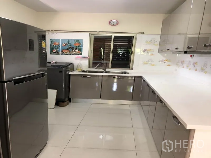 独立式住宅 出租在Suan Luang, Bangkok - 现代U型厨房，亮面橱柜、白色台面与窗户
