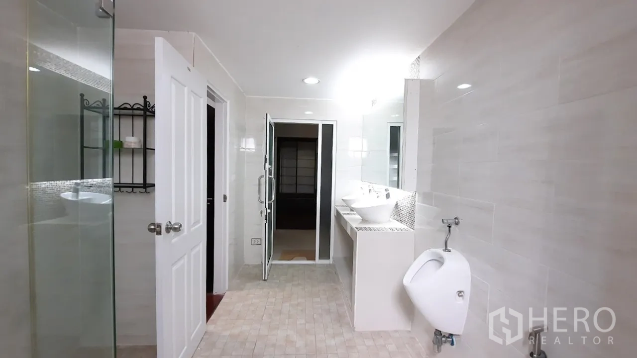 Townhouse for sale in Suan Luang, Bangkok - Spacious bathroom with double vanity, glass shower and urinal