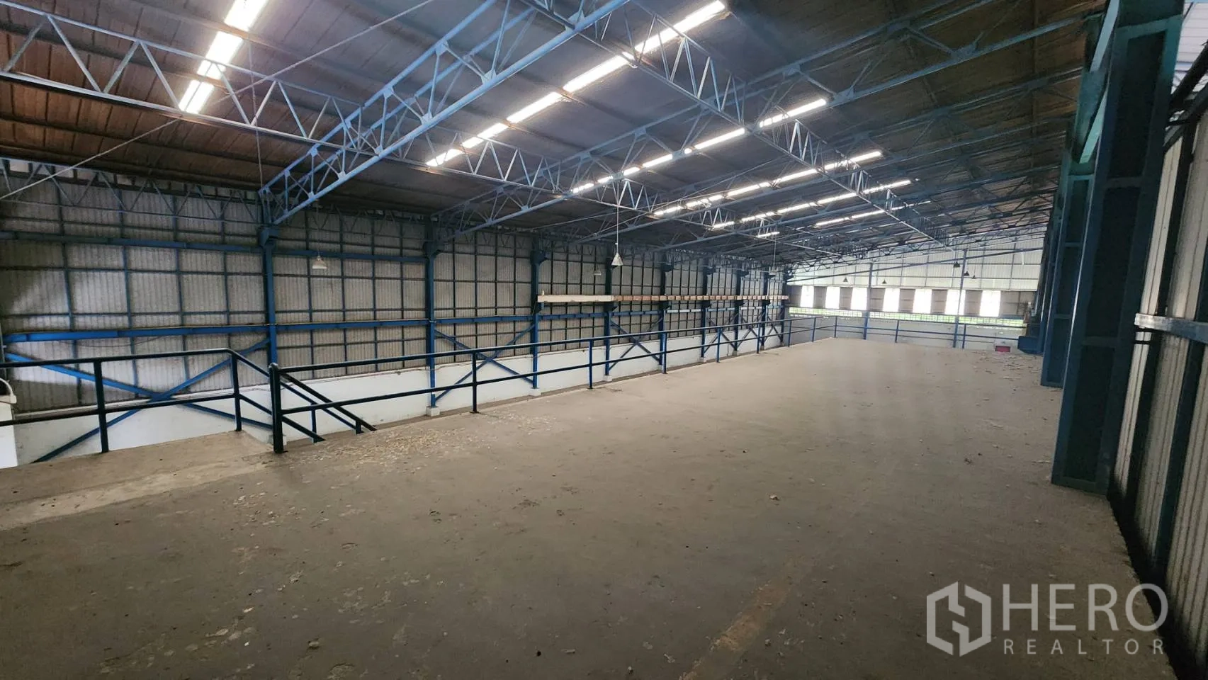 Warehouse for rent in Mueang Samut Prakan, Samut Prakan - Long mezzanine storage platform with safety railings beneath a steel roof structure.