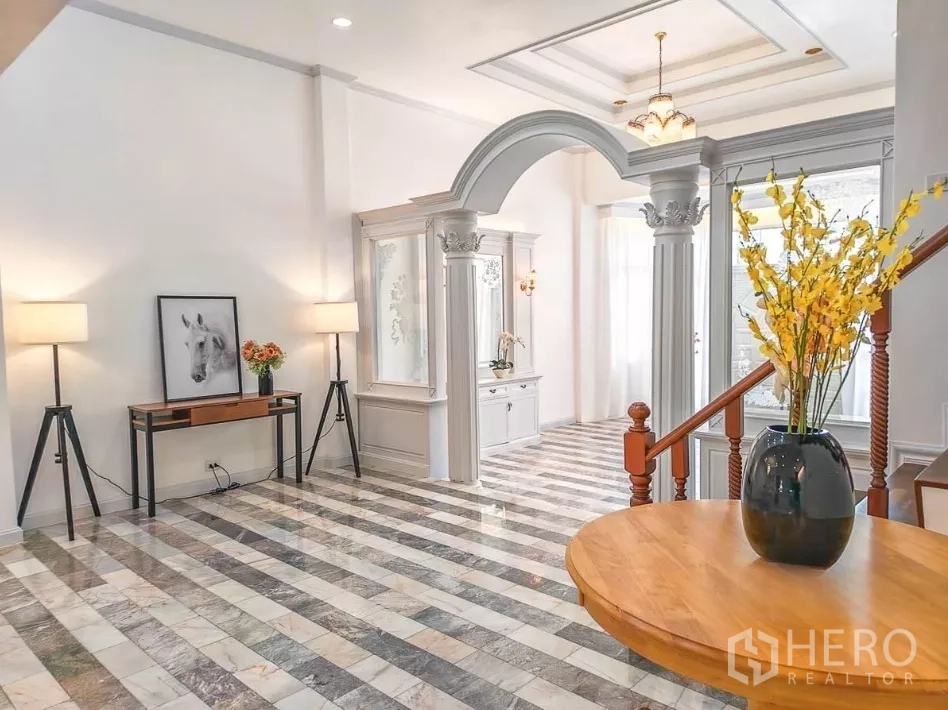 Detached House for rent in Yan Nawa, Bangkok - Grand foyer with striped marble flooring, arched doorway, and decorative columns.