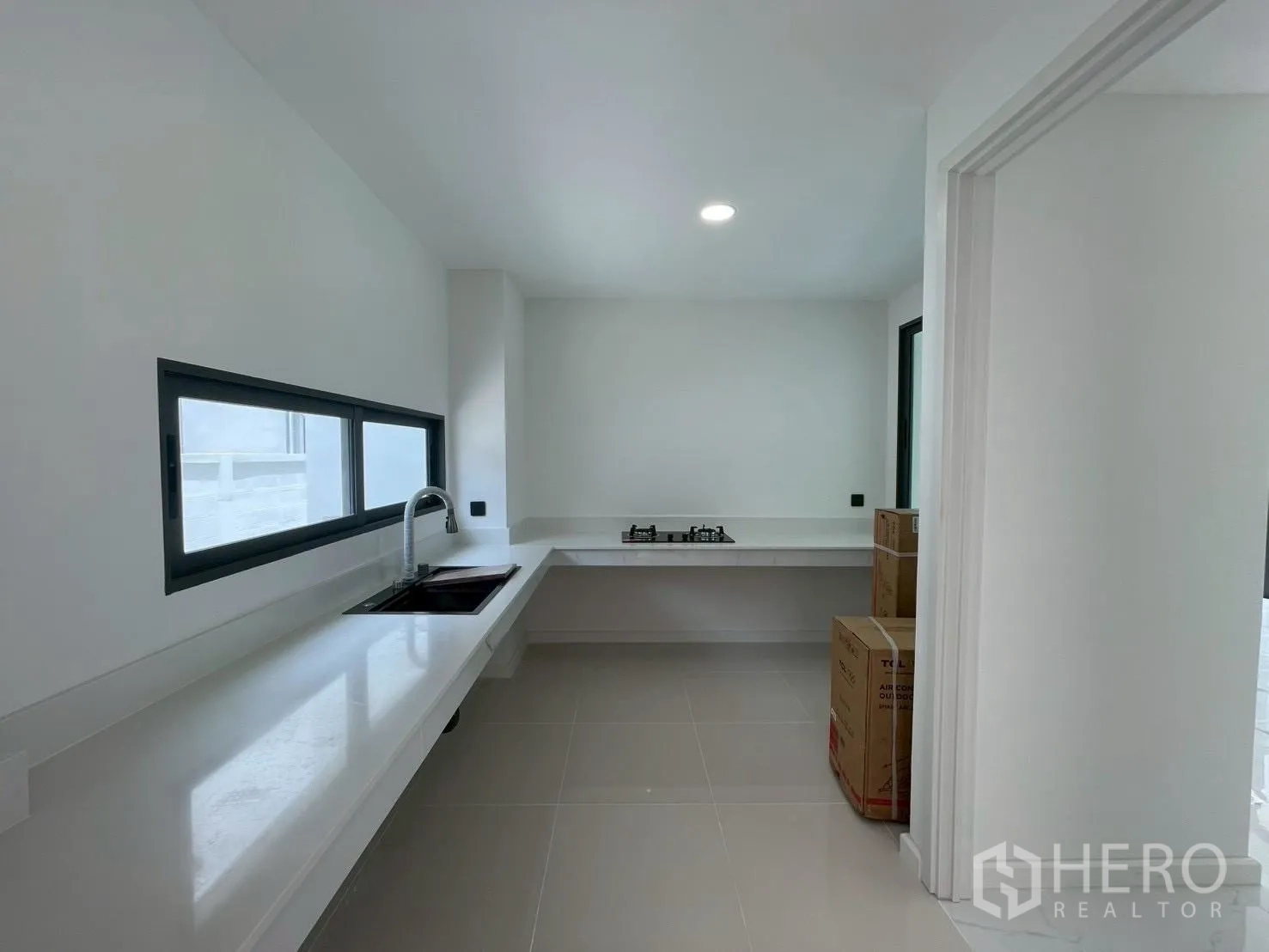 บ้านเดี่ยว for sale in Chatuchak, Bangkok - ห้องครัวมินิมอล เคาน์เตอร์ยาว อ่างล้างจาน เตาแก๊ส และช่องหน้าต่าง