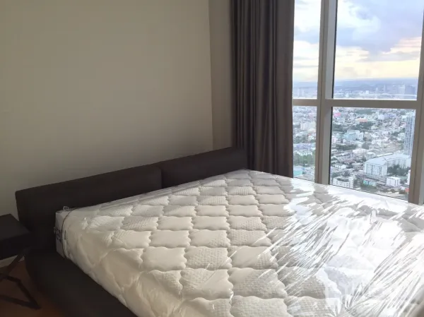 Condominium for rent or sale in Khlong San, Bangkok - Master bedroom with large window and sweeping skyline and river views.