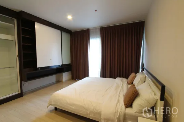 Condominium for rent or sale in Watthana, Bangkok - Cozy second bedroom with double bed, floor-to-ceiling curtains and built-in storage in a Watthana Bangkok condo.