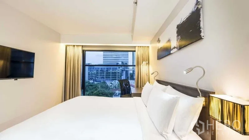 อพาร์ทเมนท์ ให้เช่าในWatthana, Bangkok - ห้องนอนหลักพร้อมเตียง โคมไฟหัวเตียง งานศิลป์ และหน้าต่างวิวเมือง.