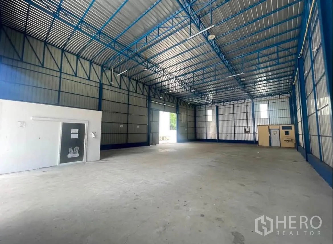 仓库 for rent in Wang Thonglang, Bangkok - 仓库内部空间开阔，高金属桁架屋顶、混凝土地面与小型隔间。