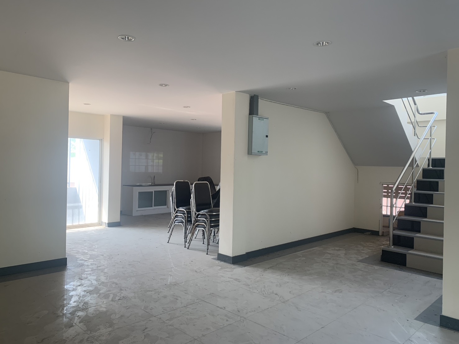 Warehouse for rent in Lam Luk Ka, Pathum Thani - Open-plan office space with a pantry area and stairs in the warehouse building.