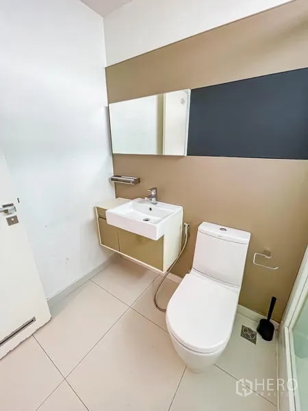Condominium for sale - Small bathroom with vanity, mirror and toilet on light tile flooring.