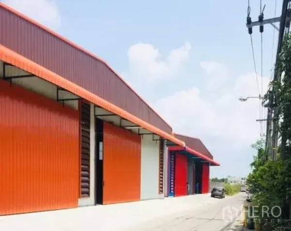 货栈 出租在Bueng Kum, Bangkok - 一排橙色金属外墙的现代仓库，临宽阔车道，卡车通行便捷。