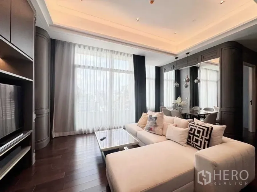Condominium for rent in Watthana, Bangkok - Stylish living-dining room with sectional sofa, high ceilings and sheer drapes.