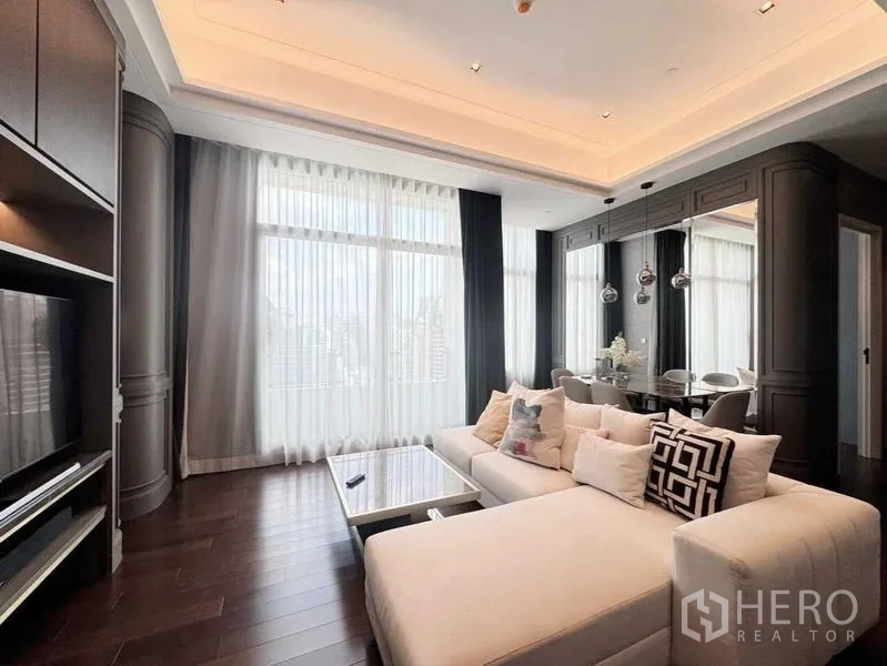 Condominium for rent in Watthana, Bangkok - Stylish living-dining room with sectional sofa, high ceilings and sheer drapes.