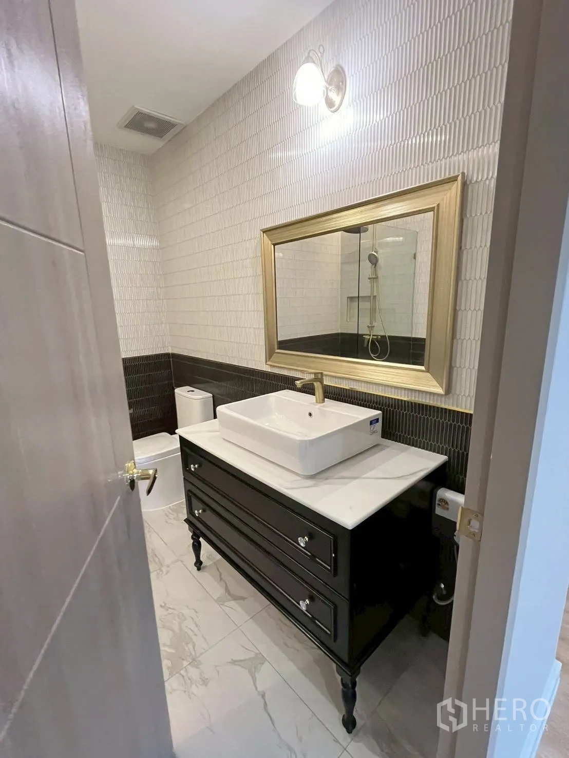 联排别墅 for rent in Khlong Toei, Bangkok - 紧凑浴室，设黑色洗手台、壁灯与地砖。
