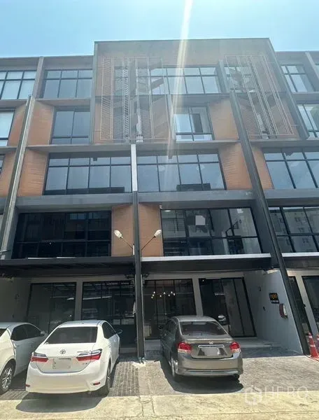 带办公室的家 出租 - 建筑正面另一视角，大窗与现场停车位。