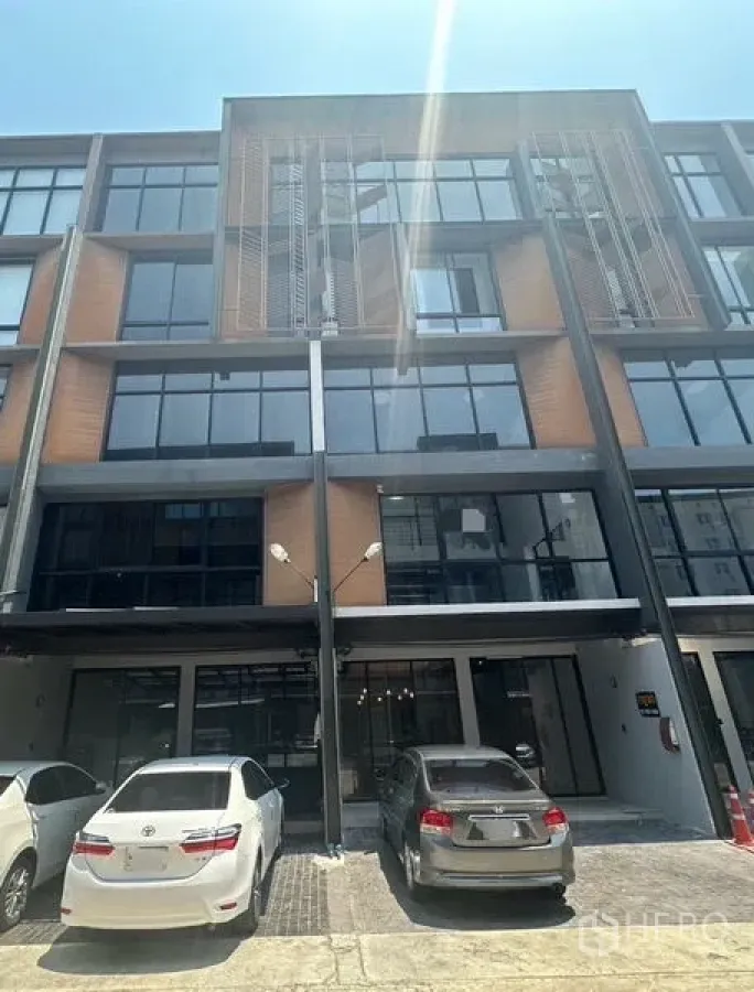 带办公室的家 出租 - 建筑正面另一视角，大窗与现场停车位。