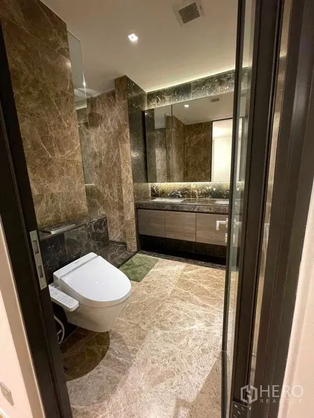 Condominium for rent in Pathum Wan, Bangkok - Open-plan living space viewed from the kitchen sink with sheer curtains and a city backdrop.