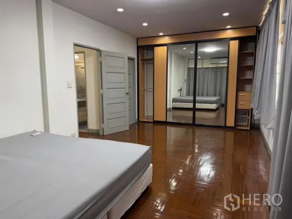 独立式住宅 出租在Bang Kapi, Bangkok - 宽敞卧室，镜面衣柜、木地板并设有套间门。