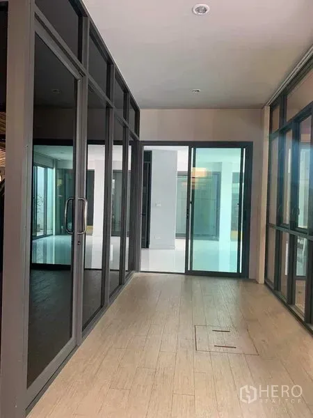 联排别墅 出租或出售在Yan Nawa, Bangkok - 室内走廊，落地玻璃隔断与木纹地砖。