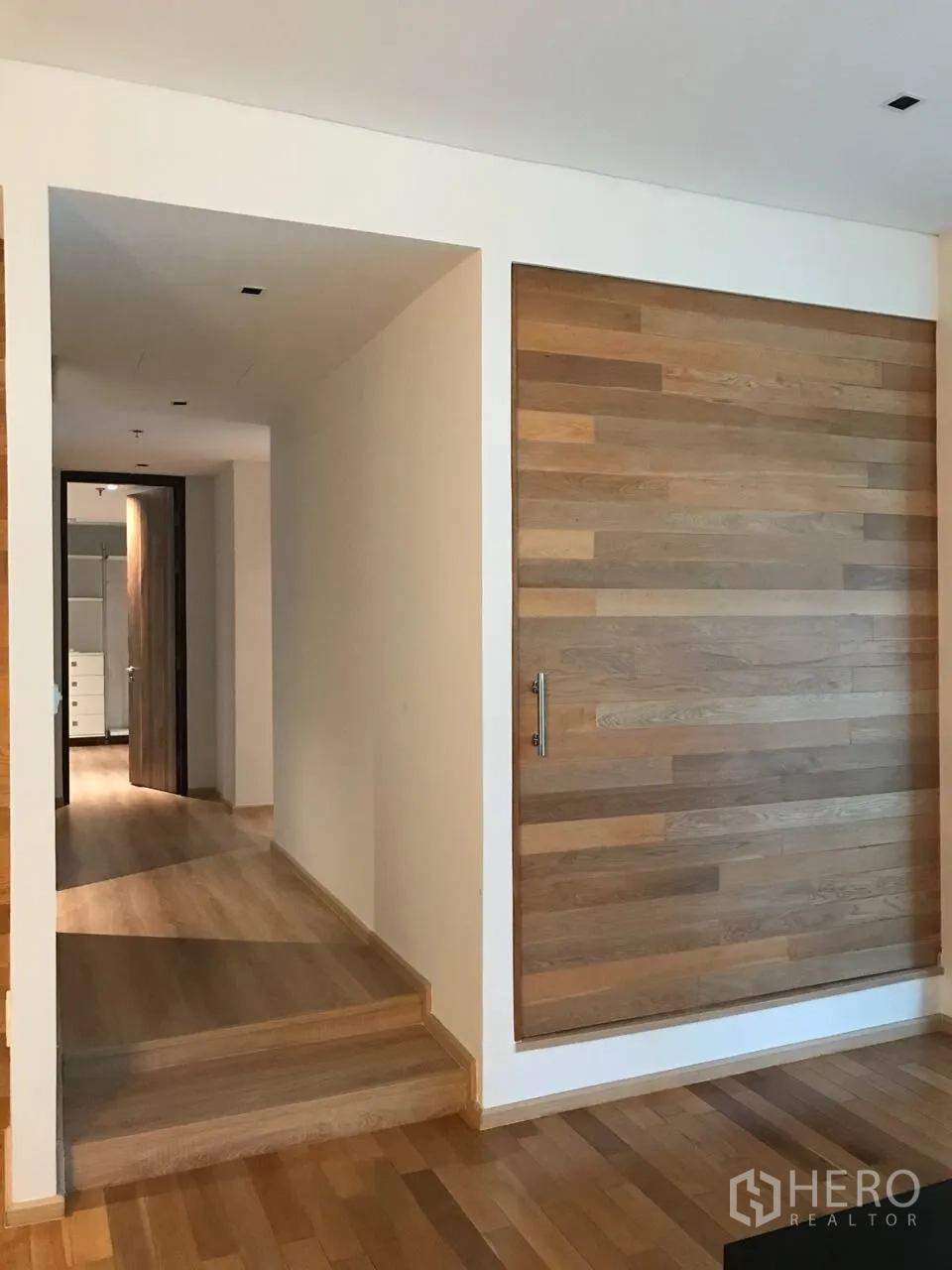 Condominium for rent in Khlong Toei, Bangkok - Entry hallway with light wood flooring and a sliding timber feature wall.