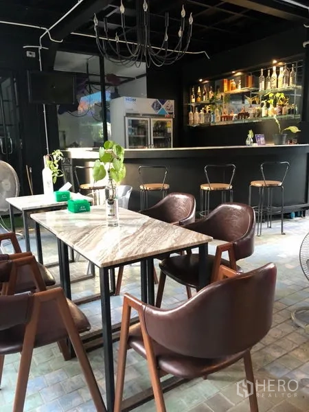 Retail Space for rent in Khlong Toei, Bangkok - Stylish indoor bar with marble tables, leather chairs, and a backlit bottle display.