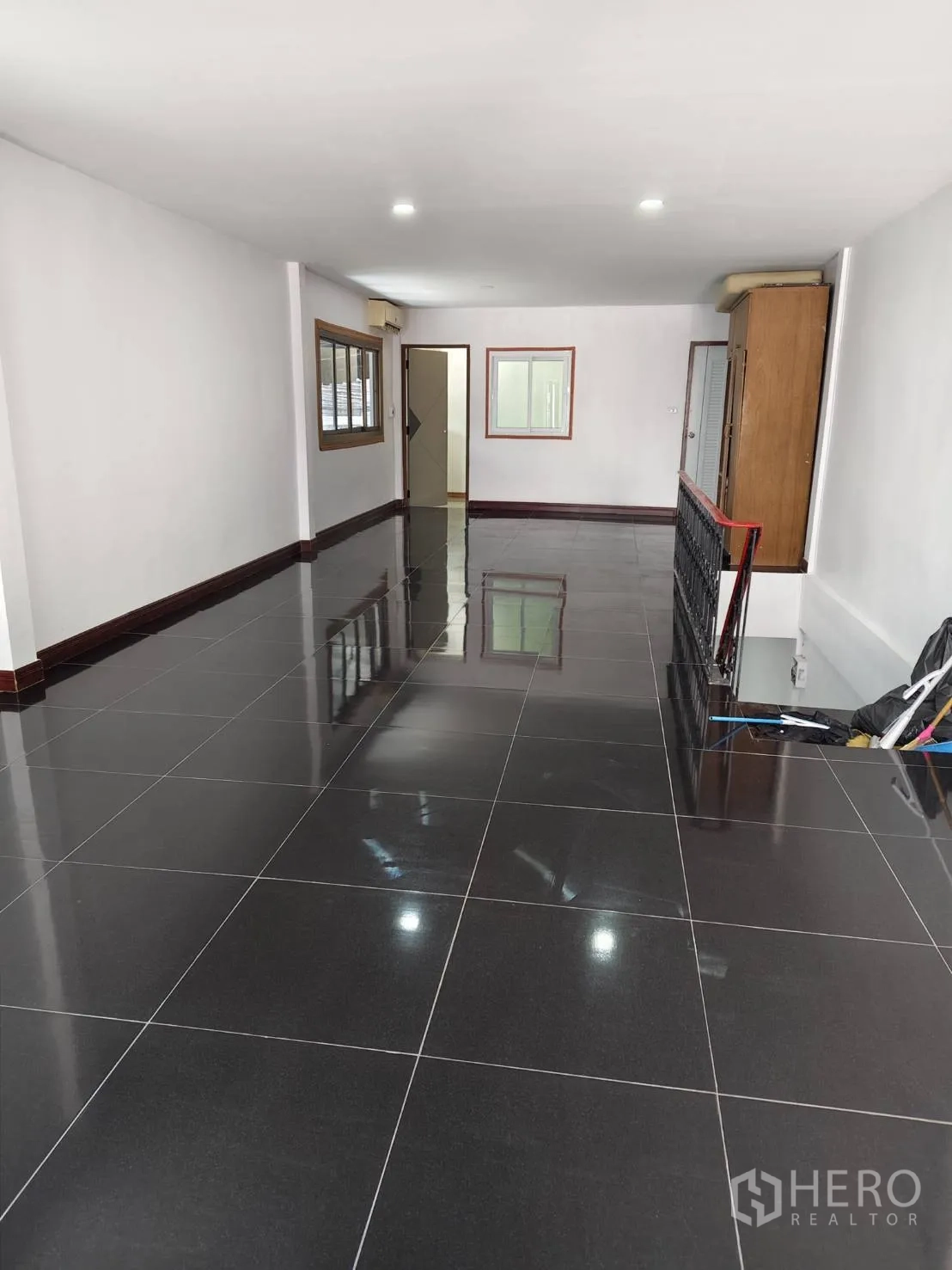 Townhouse for sale in Phra Khanong, Bangkok - Upstairs hallway view leading to bedrooms with built-in cabinet and windows.