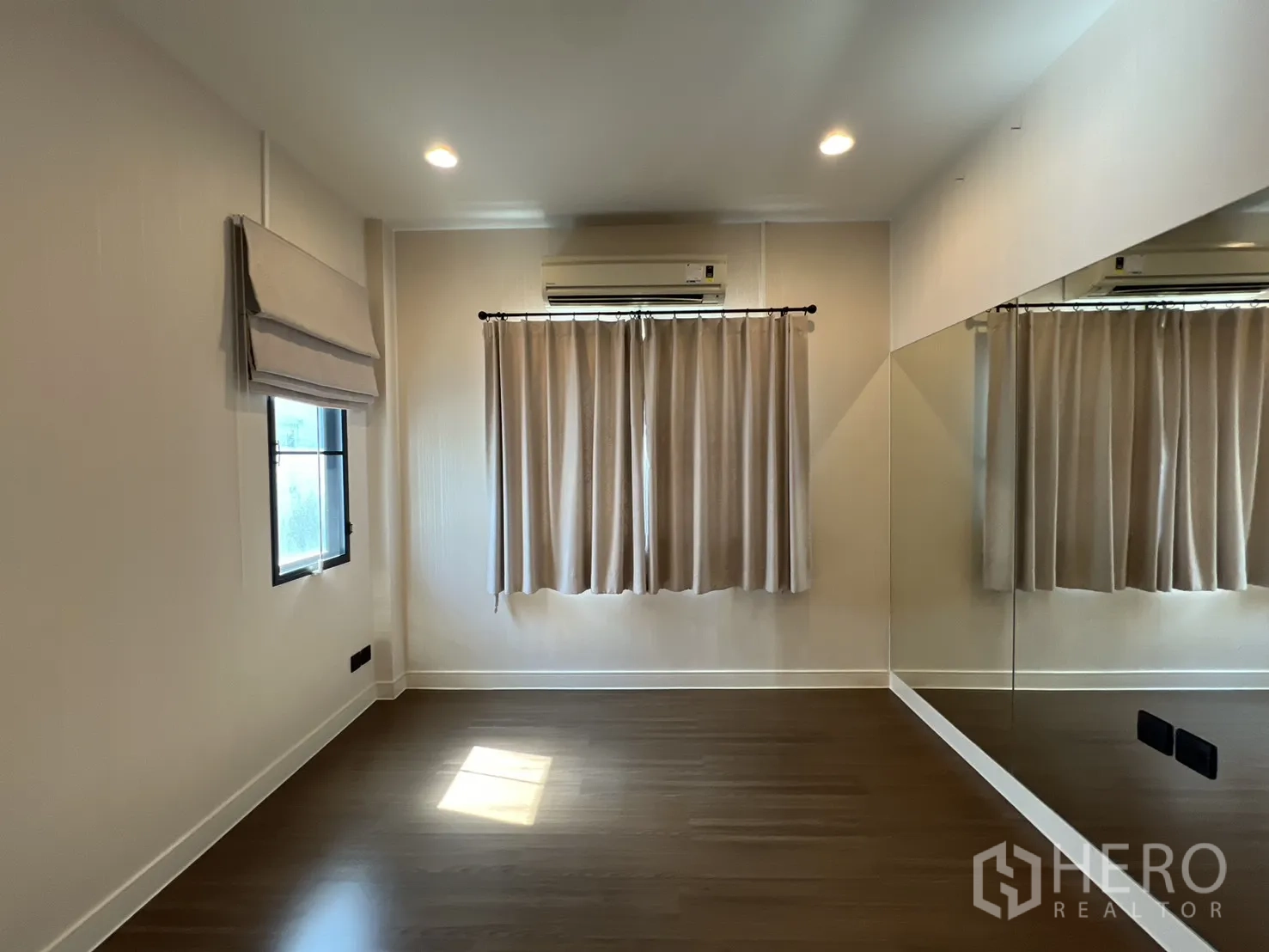 Detached House for sale in Bang Kapi, Bangkok - Bedroom or studio with a full-wall mirror and wood floor.