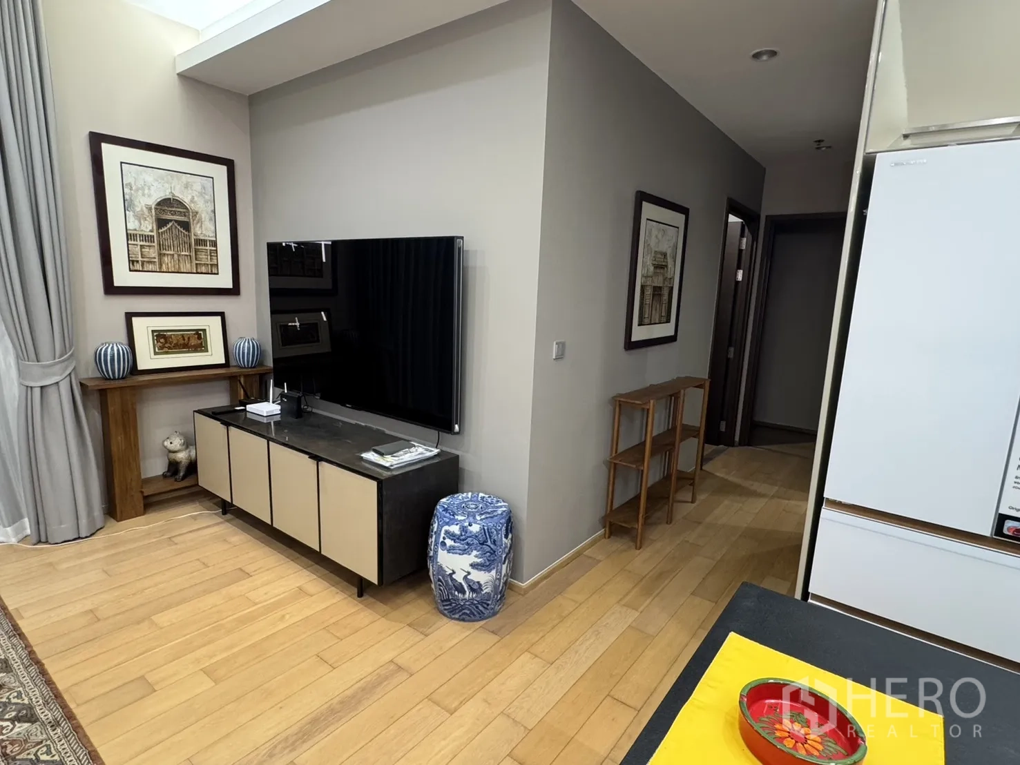 公寓 for rent in Watthana, Bangkok - 客厅配大屏电视、电视柜、装饰画与灰色窗帘。