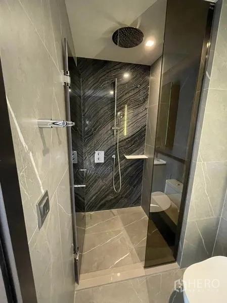 คอนโด ขายในWatthana, Bangkok - ห้องน้ำสมัยใหม่พร้อมตู้กระจกและฝักบัวเรนชาวเวอร์ผนังหินสีเข้ม