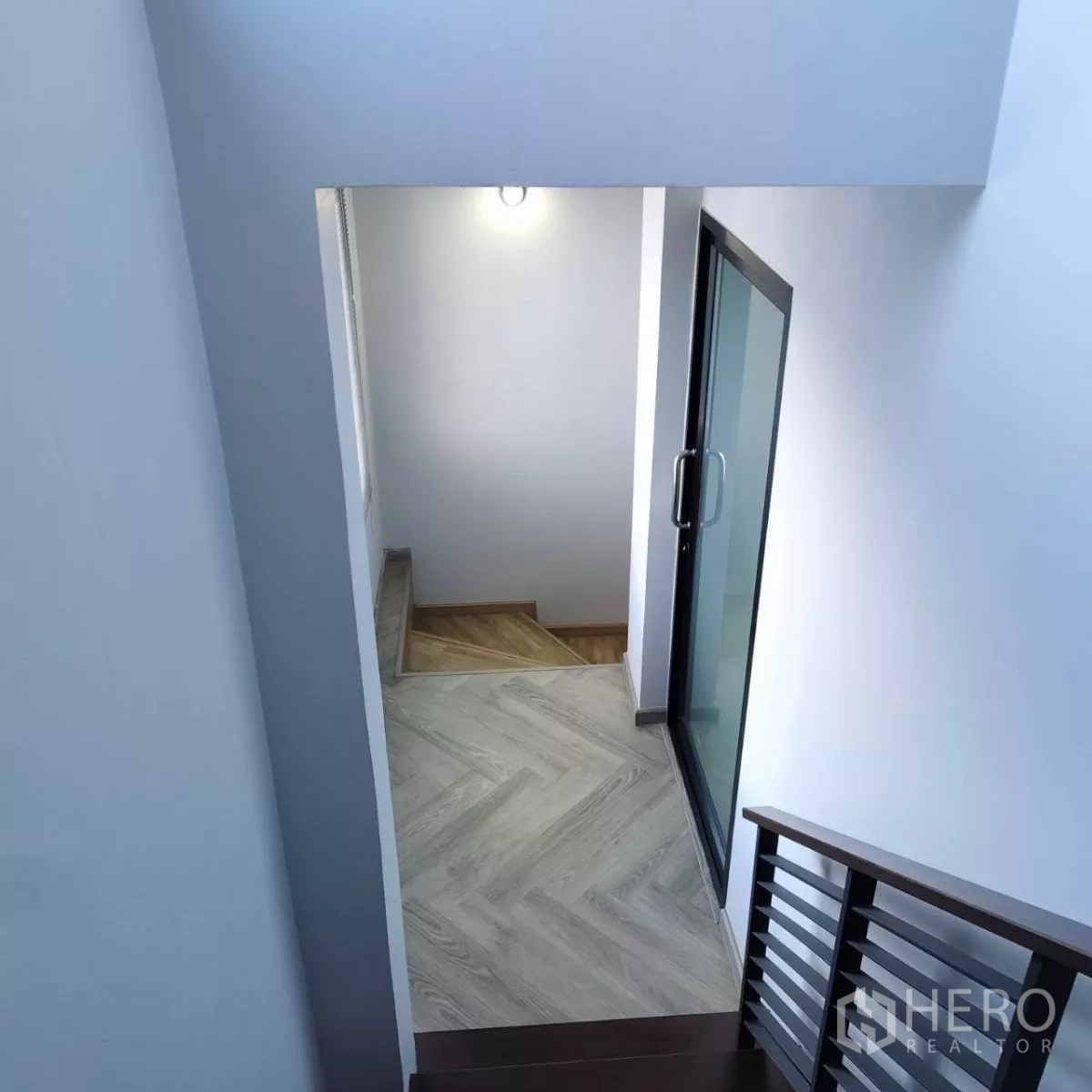 带办公室的家 出租或出售在Watthana, Bangkok - 楼梯间视角，可见推拉玻璃门与木纹地板。