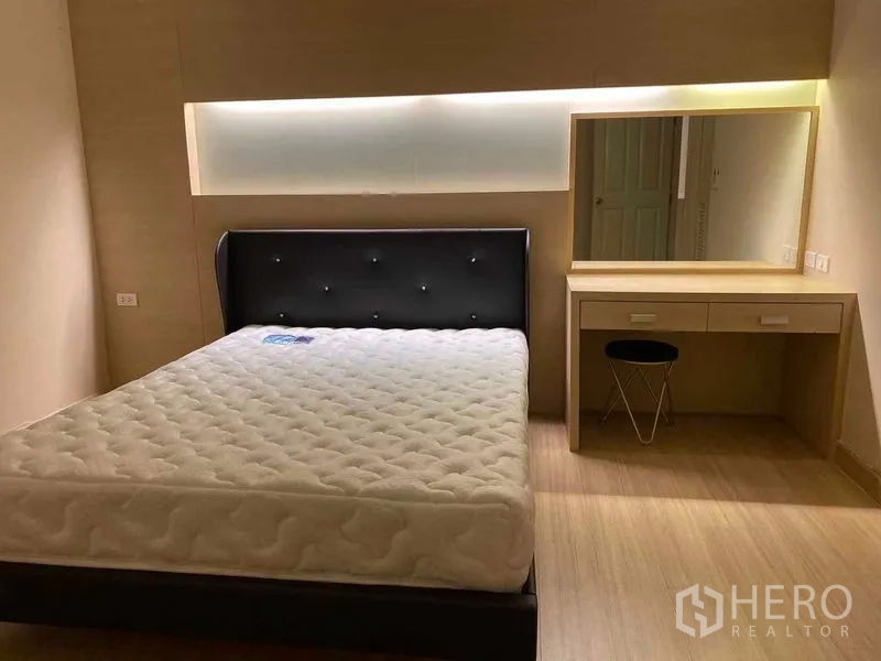 公寓 出租在Khlong San, Bangkok - 次卧配软包床与梳妆台，灯光温暖。