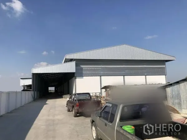 Warehouse for rent in Bang Phli, Samut Prakan - Front view of large metal-clad warehouse with ample truck parking area.