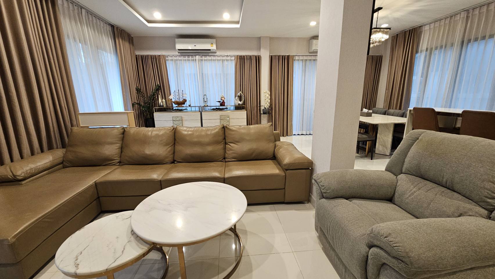Detached House for rent in Saphan Sung, Bangkok - Spacious lounge with L-shaped leather sofa and nesting marble coffee tables.