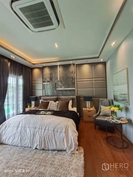 独立式住宅 出售在Wang Thonglang, Bangkok - 主卧另一角度，特色背景墙、长绒地毯与床头柜台灯。