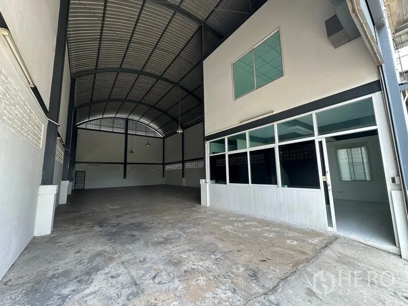Factory for rent in Bang Bua Thong, Nonthaburi - Spacious factory floor with high arched steel roof, concrete slab and glass-partitioned office at the front.