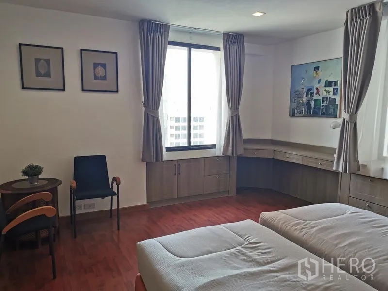 公寓 出租或出售在Watthana, Bangkok - 大卧室一角，宽窗、环形书桌与小圆桌椅