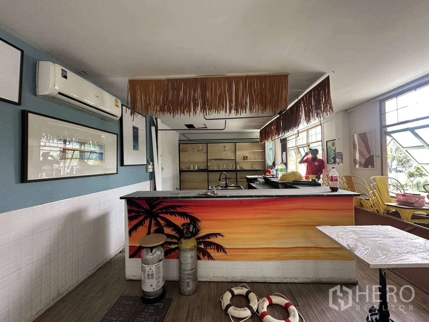 零售空间 for rent in Sathon, Bangkok - 彩色热带风吧台，后方货架与可开启窗户的零售空间。