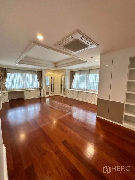 Condominium for rent in Bangkok - Large master bedroom with hardwood floor, tray ceiling and built-in white cabinetry.